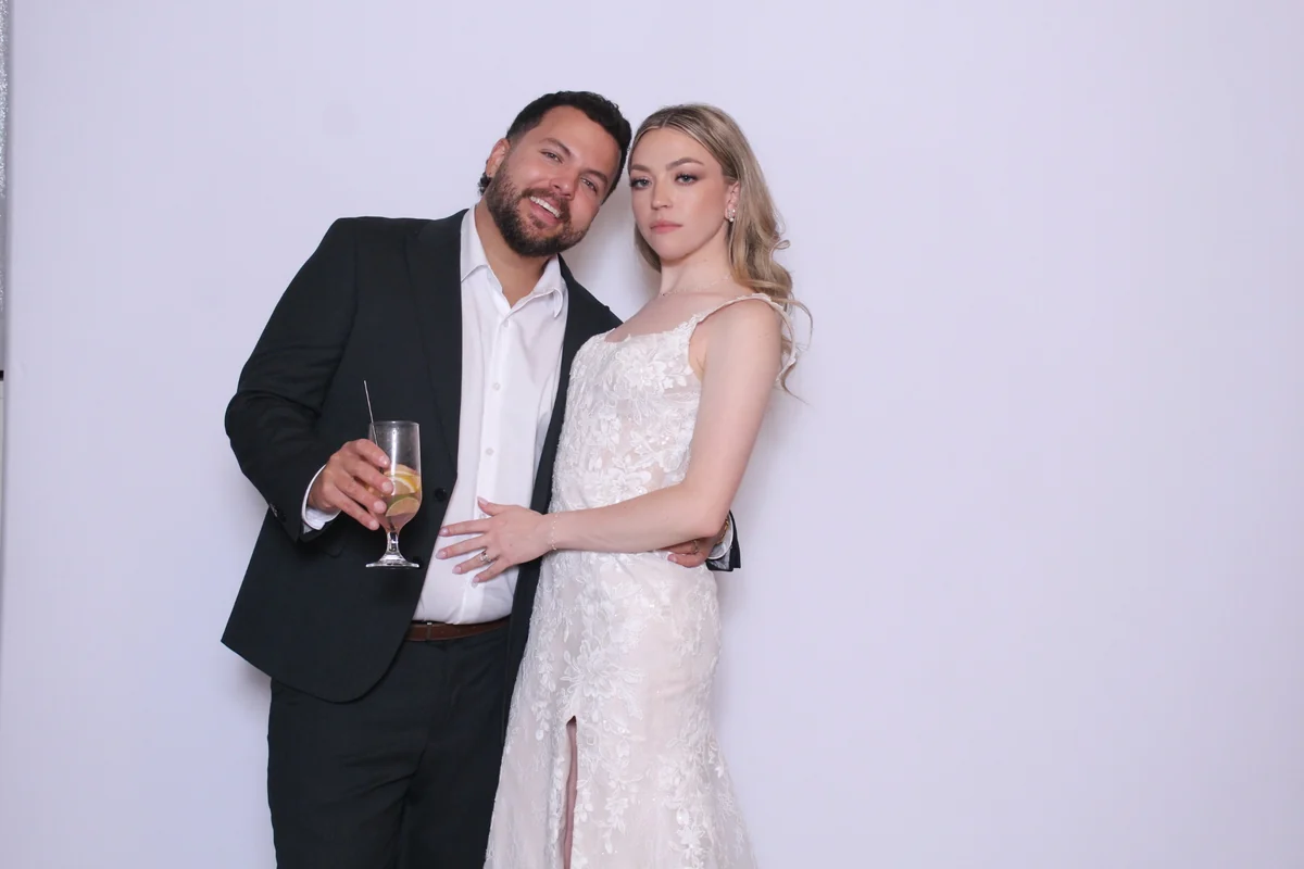Nicole and Alex posing together in their wedding photo booth