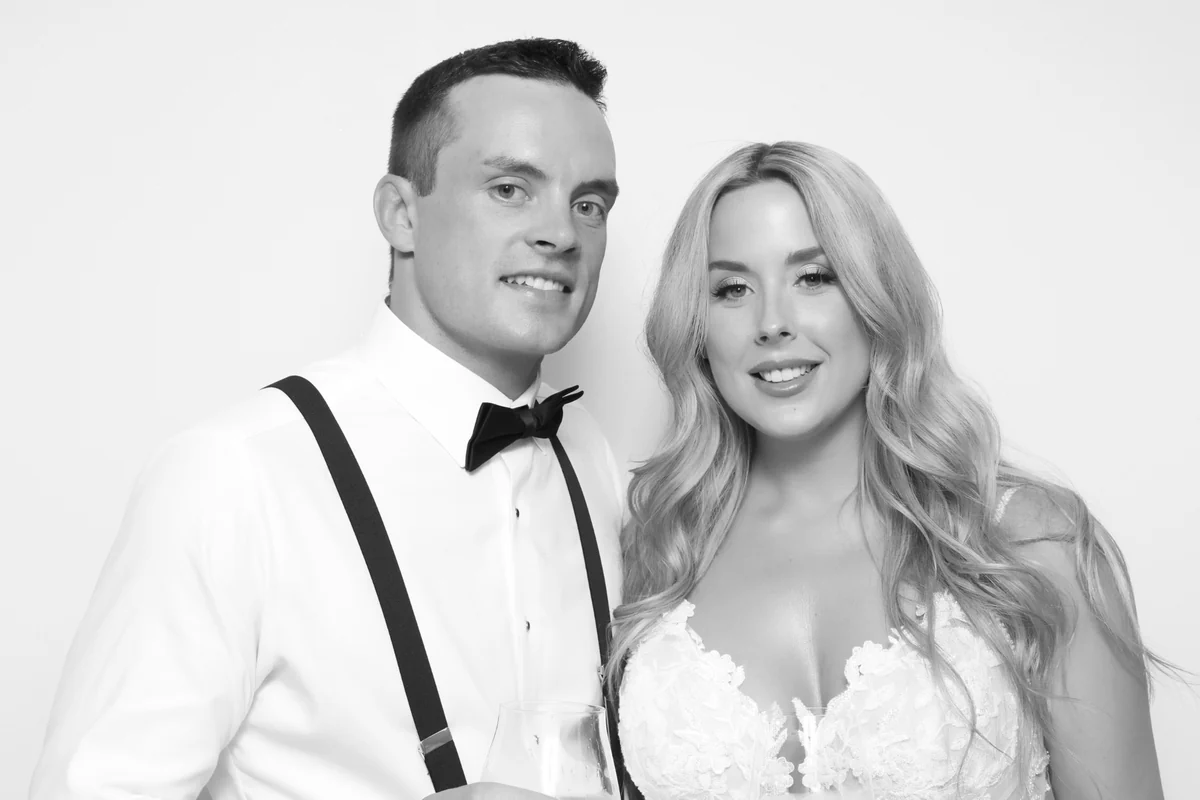 The Potvins smiling together in a black-and-white photo booth portrait