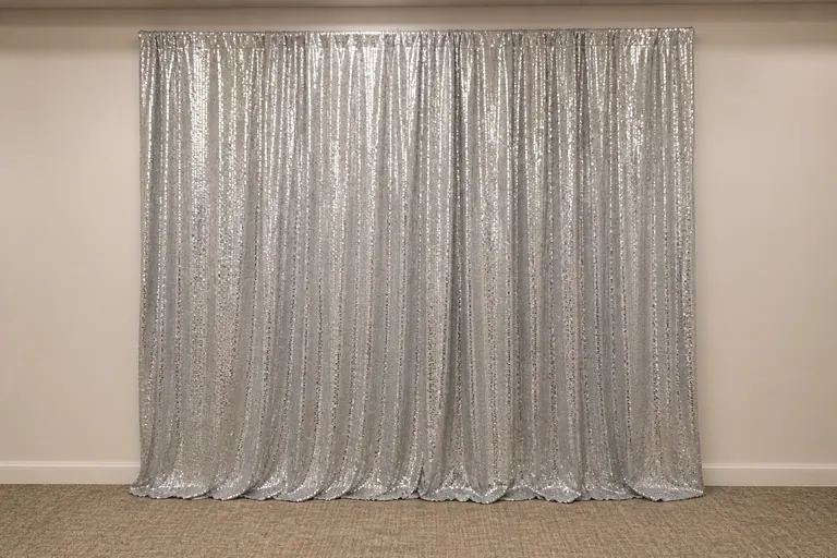 Silver sequin photo booth backdrop staged in a neutral event space