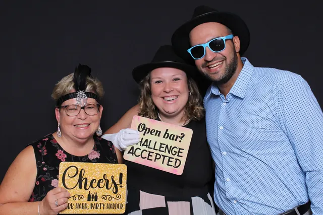 Guests enjoying a photo booth with a dark backdrop, photo 1