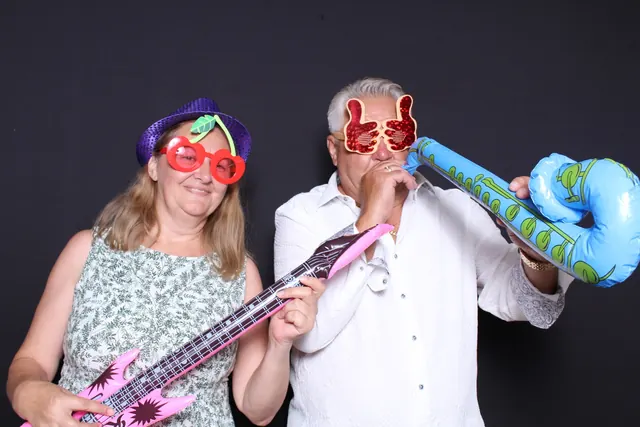 Guests enjoying a photo booth with a dark backdrop, photo 2