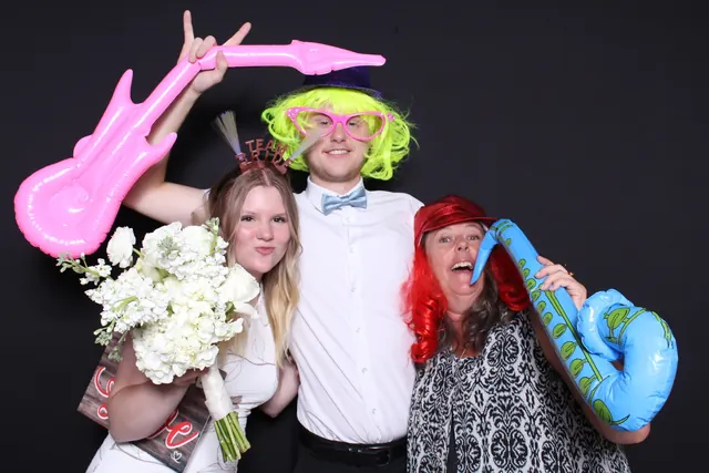 Guests enjoying a photo booth with a dark backdrop, photo 5