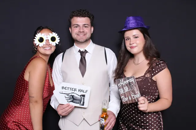 Guests enjoying a photo booth with a dark backdrop, photo 6