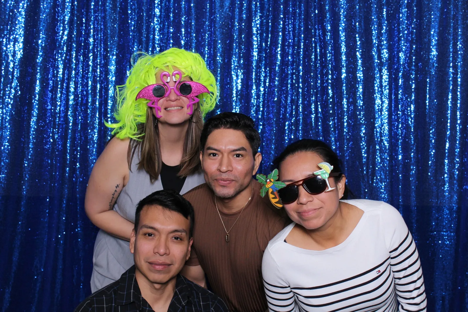 Guests enjoying a photo booth with a blue sequin backdrop, photo 1