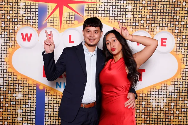 Guests enjoying a photo booth with a custom themed backdrop, photo 1
