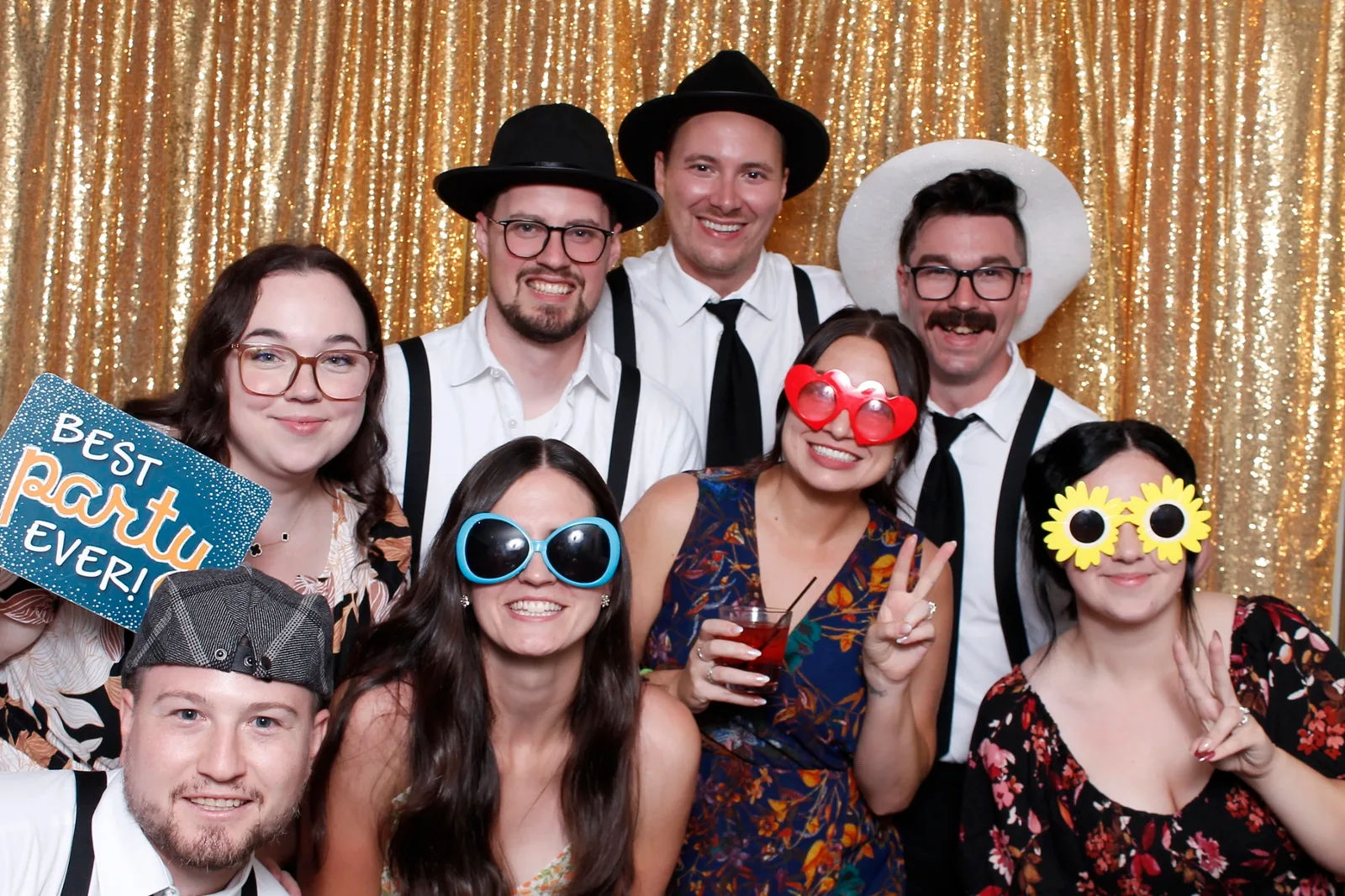 Guests enjoying a photo booth with a gold sequin backdrop, photo 2