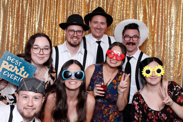 Guests enjoying a photo booth with a gold sequin backdrop, photo 2