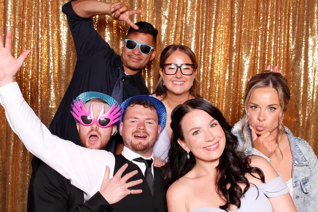 Guests enjoying a photo booth with a gold sequin backdrop, photo 8