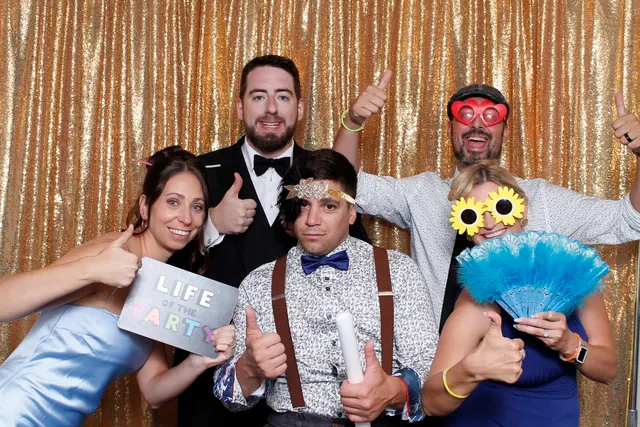 Guests enjoying a photo booth with a gold sequin backdrop, photo 9