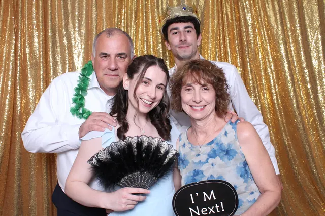 Guests enjoying a photo booth with a gold sequin backdrop, photo 13