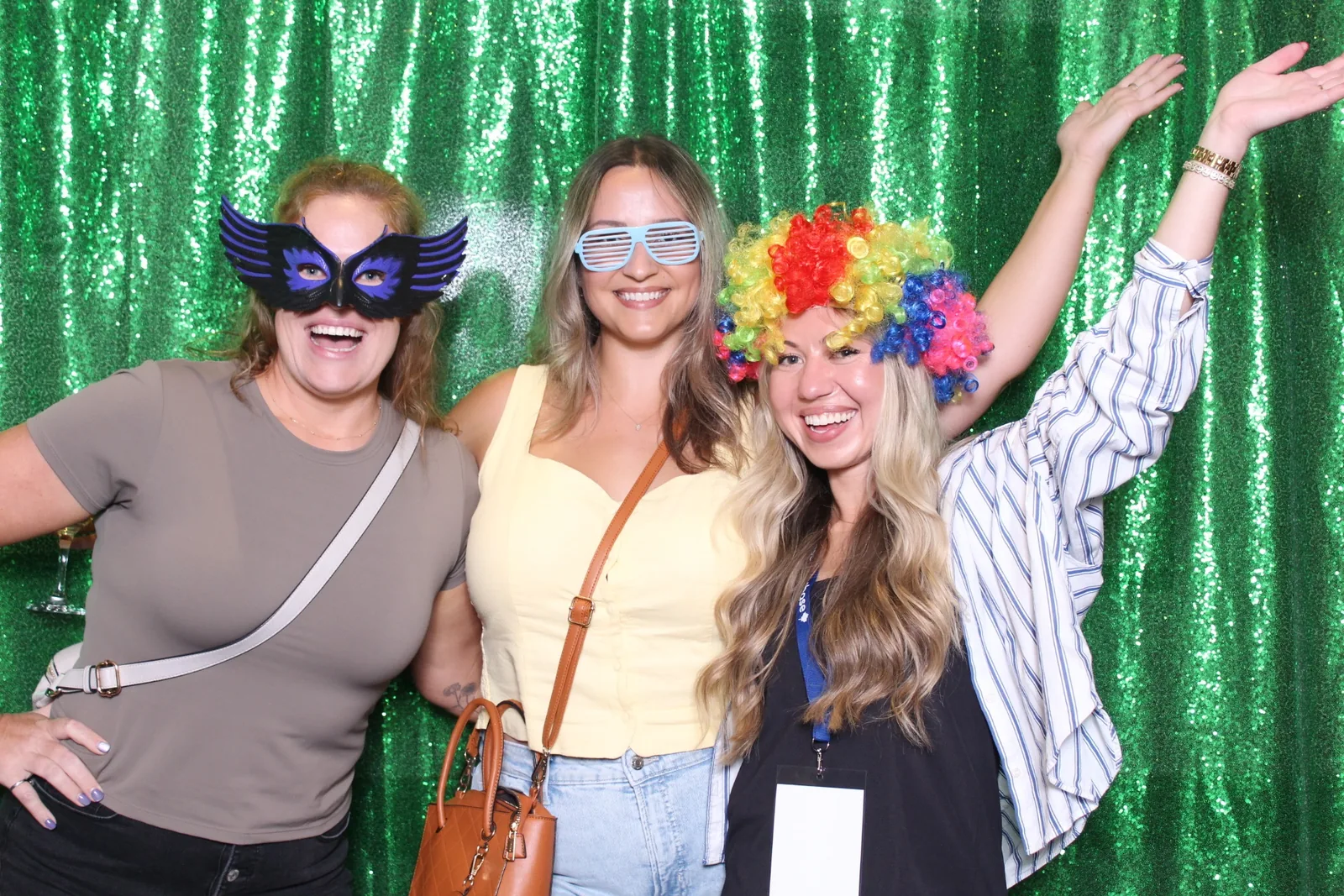 Guests enjoying a photo booth with a green backdrop, photo 1