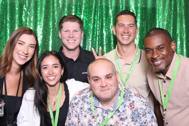 Guests enjoying a photo booth with a green backdrop, photo 3