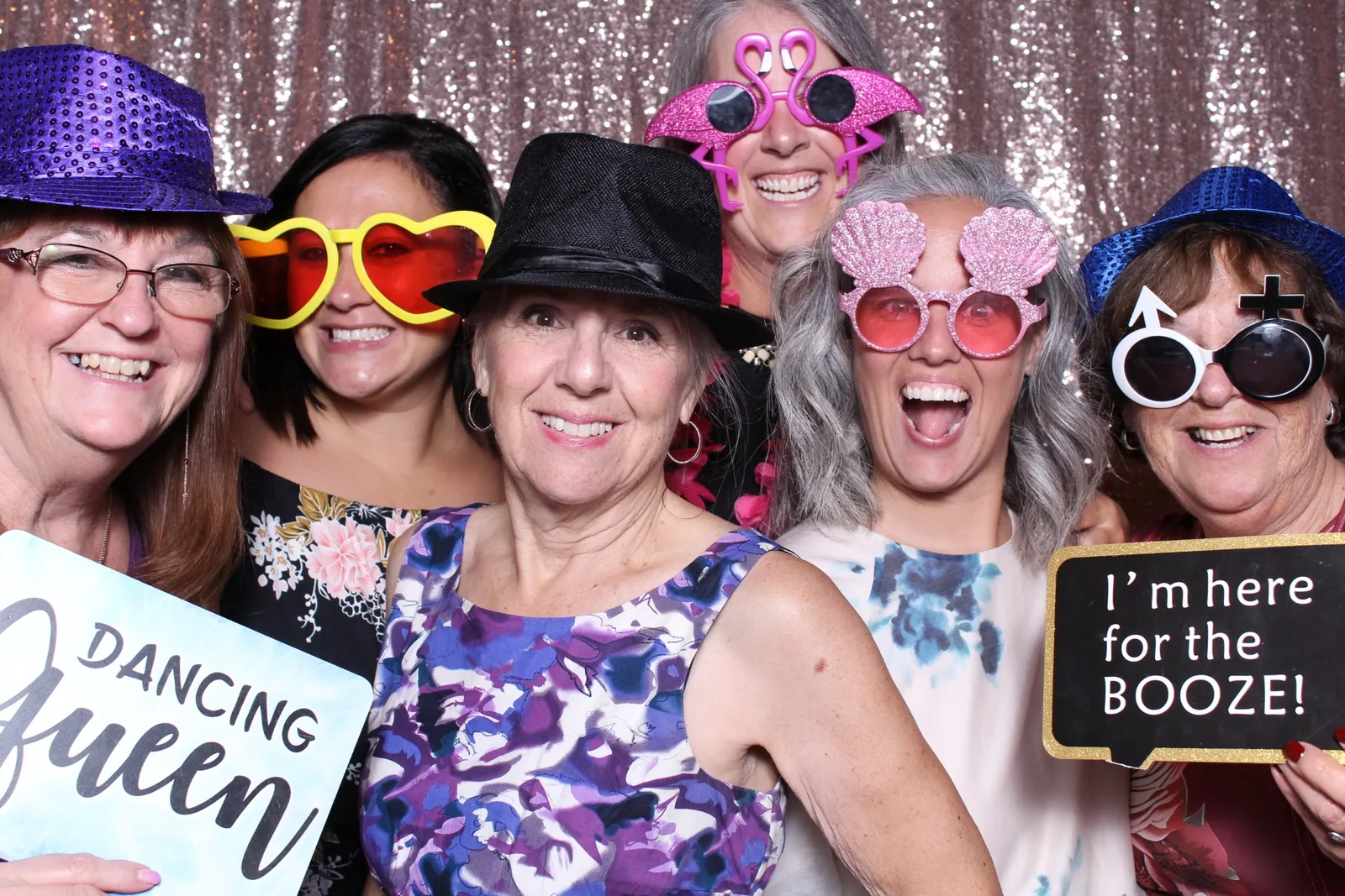Guests enjoying a photo booth with a rose-gold sequin backdrop, photo 4