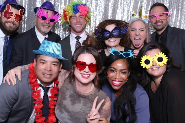 Guests enjoying a photo booth with a silver sequin backdrop, photo 3