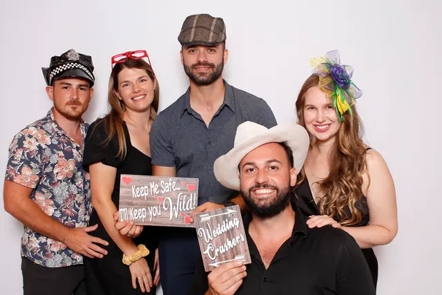 Guests enjoying a photo booth with a white neutral backdrop, photo 2
