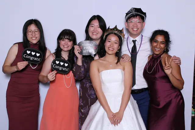 Guests enjoying a photo booth with a white neutral backdrop, photo 8