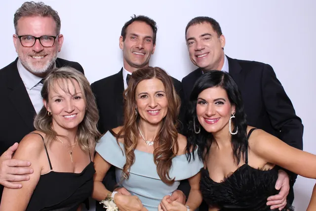 Guests enjoying a photo booth with a white neutral backdrop, photo 9