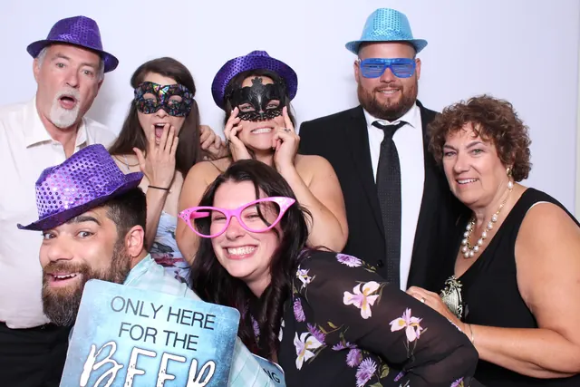 Guests enjoying a photo booth with a white neutral backdrop, photo 10