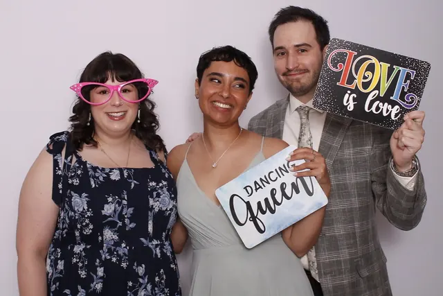 Guests enjoying a photo booth with a white neutral backdrop, photo 13