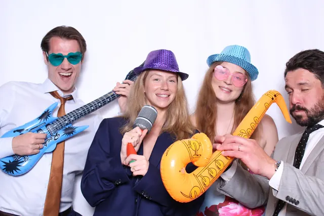 Guests enjoying a photo booth with a white neutral backdrop, photo 14