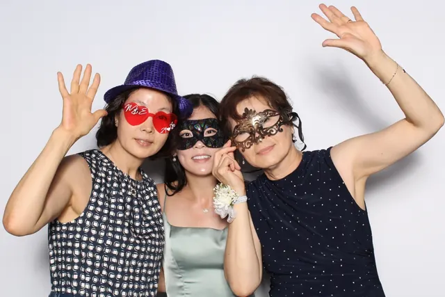 Guests enjoying a photo booth with a white neutral backdrop, photo 18