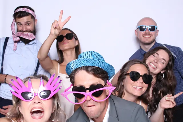 Guests enjoying a photo booth with a white neutral backdrop, photo 19