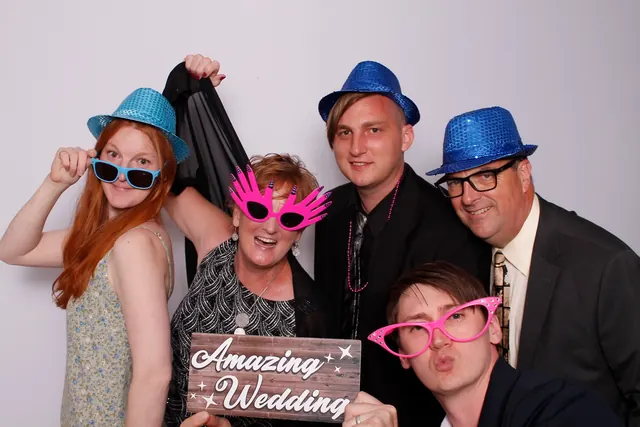 Guests enjoying a photo booth with a white neutral backdrop, photo 25