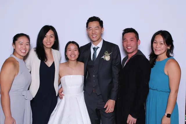 Guests enjoying a photo booth with a white neutral backdrop, photo 26