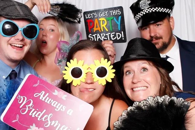 Guests enjoying a photo booth with a white neutral backdrop, photo 29