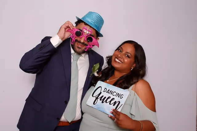 Guests enjoying a photo booth with a white neutral backdrop, photo 34