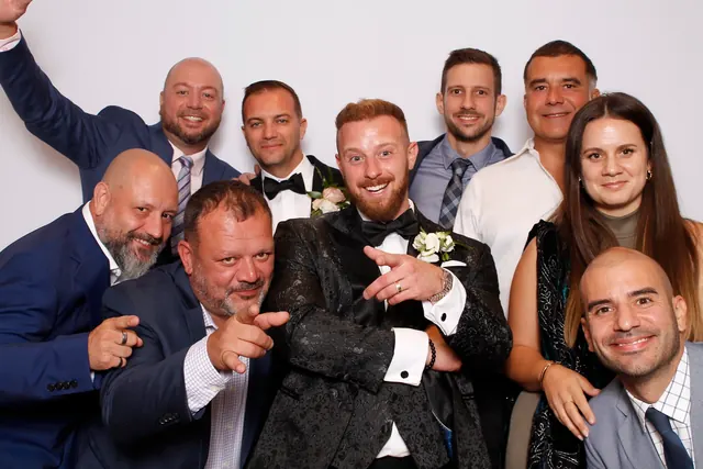 Guests enjoying a photo booth with a white neutral backdrop, photo 38