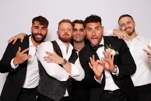 Guests enjoying a photo booth with a white neutral backdrop, photo 39